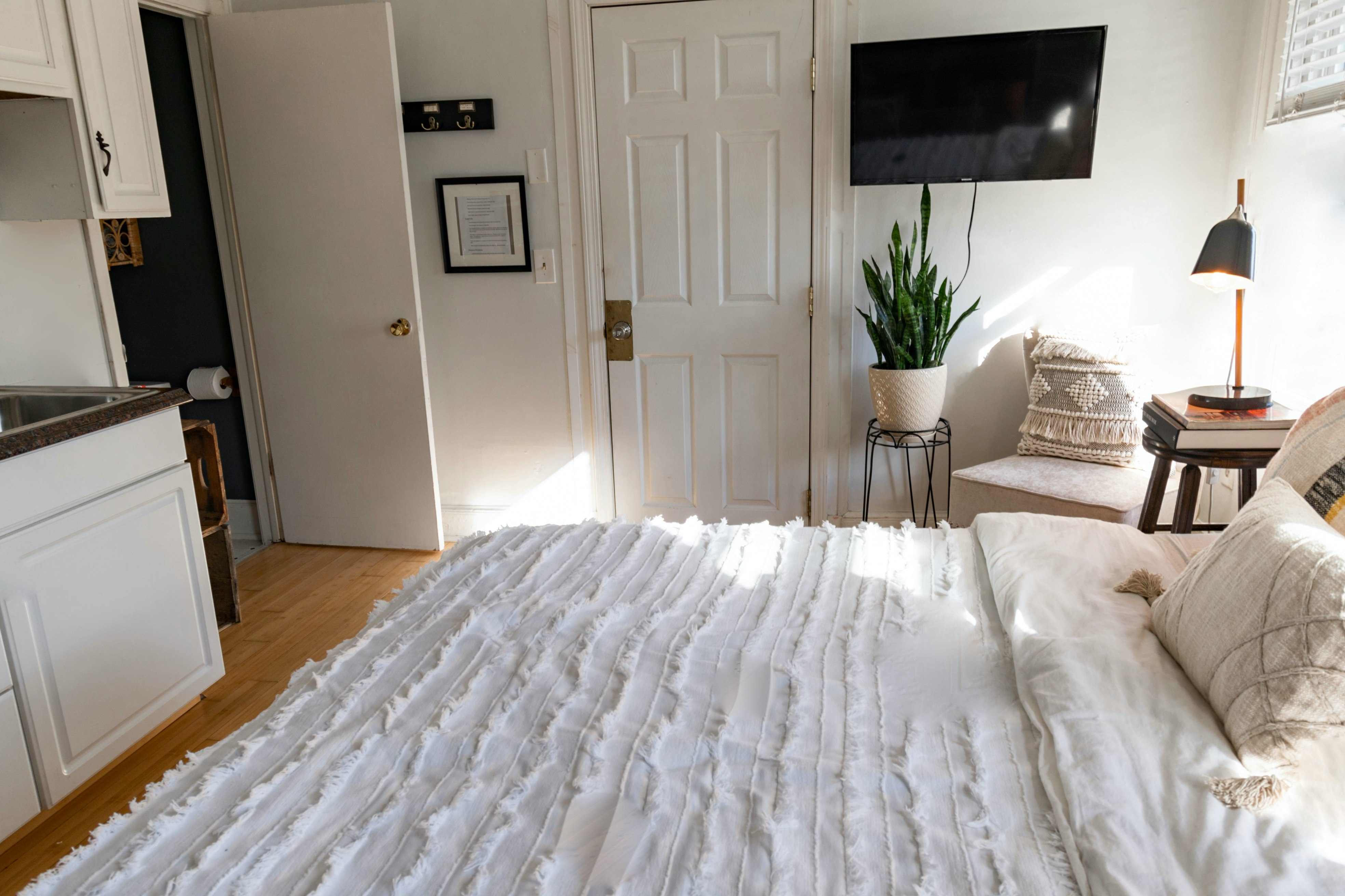 white bed cover near white wooden door